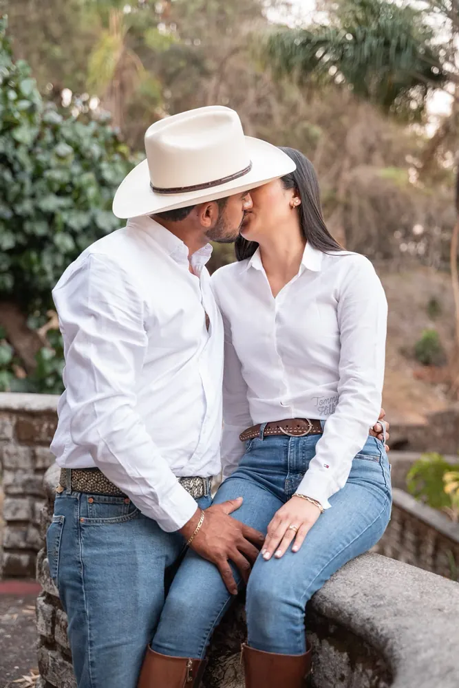 Estephany y Jorge dándose un beso con sombrero vaquero